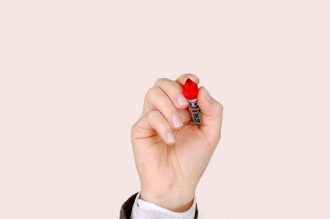 Advertising Doesn’t Cost, It Pays (Unless You’re Not Careful) | IP Law Firm | Harness IP pen marker hand the hand 40554 | Intellectual Property Law Firm | Harness IP